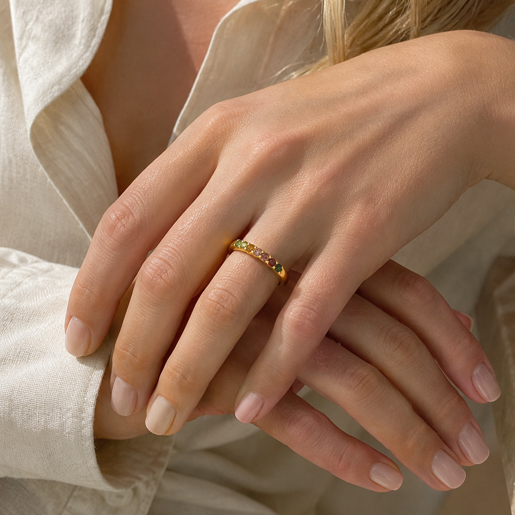 Close-up of hands with a gold ring wearing a light-colored shirt.