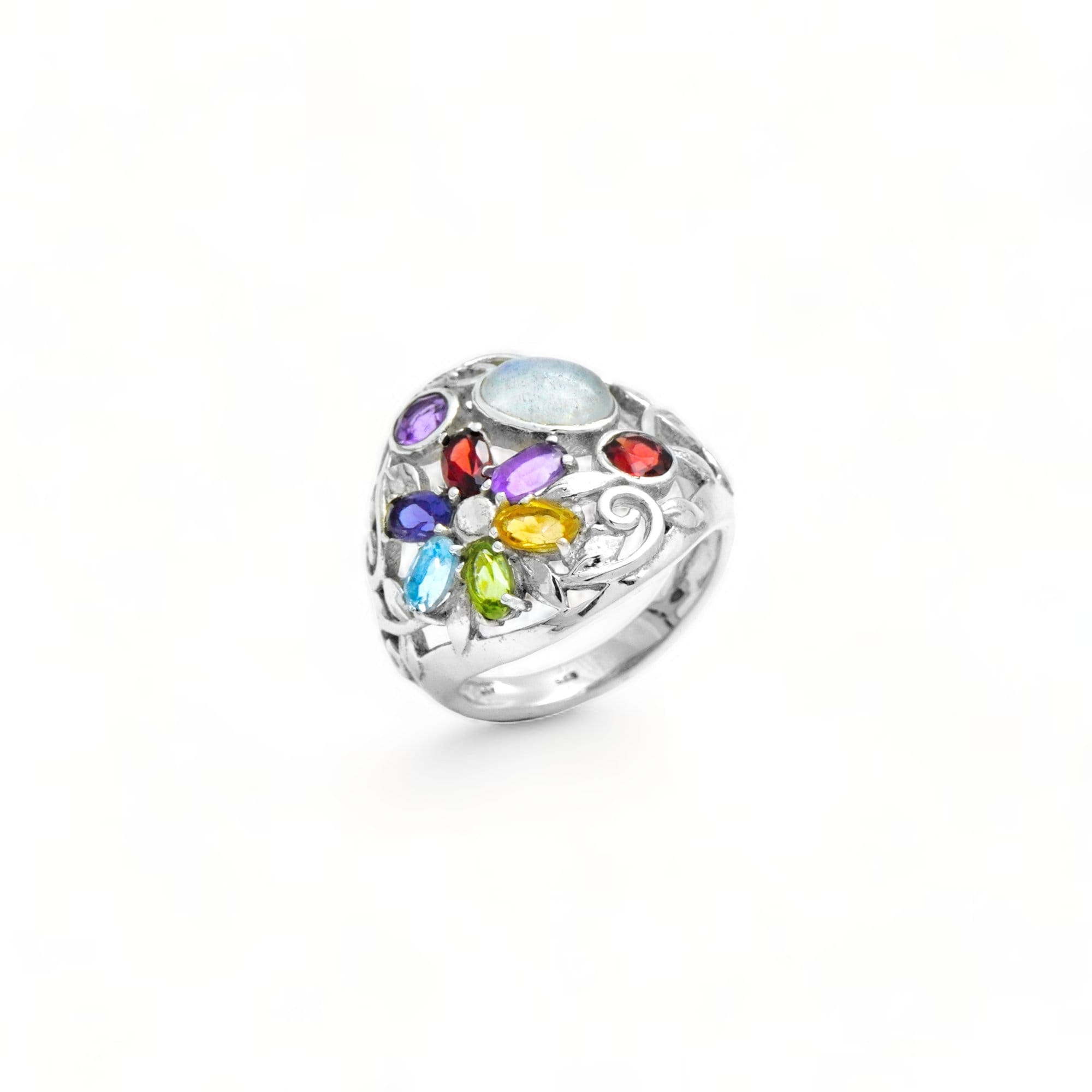 May include: A silver ring with a large oval moonstone center stone surrounded by smaller gemstones in various colors including red, yellow, green, blue, and purple. The ring is set in a floral design.