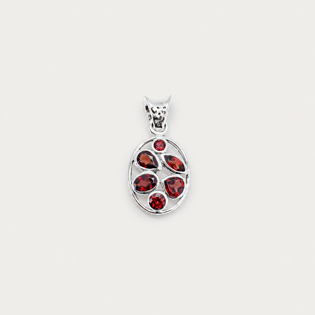 Silver pendant with red gemstones on a white background