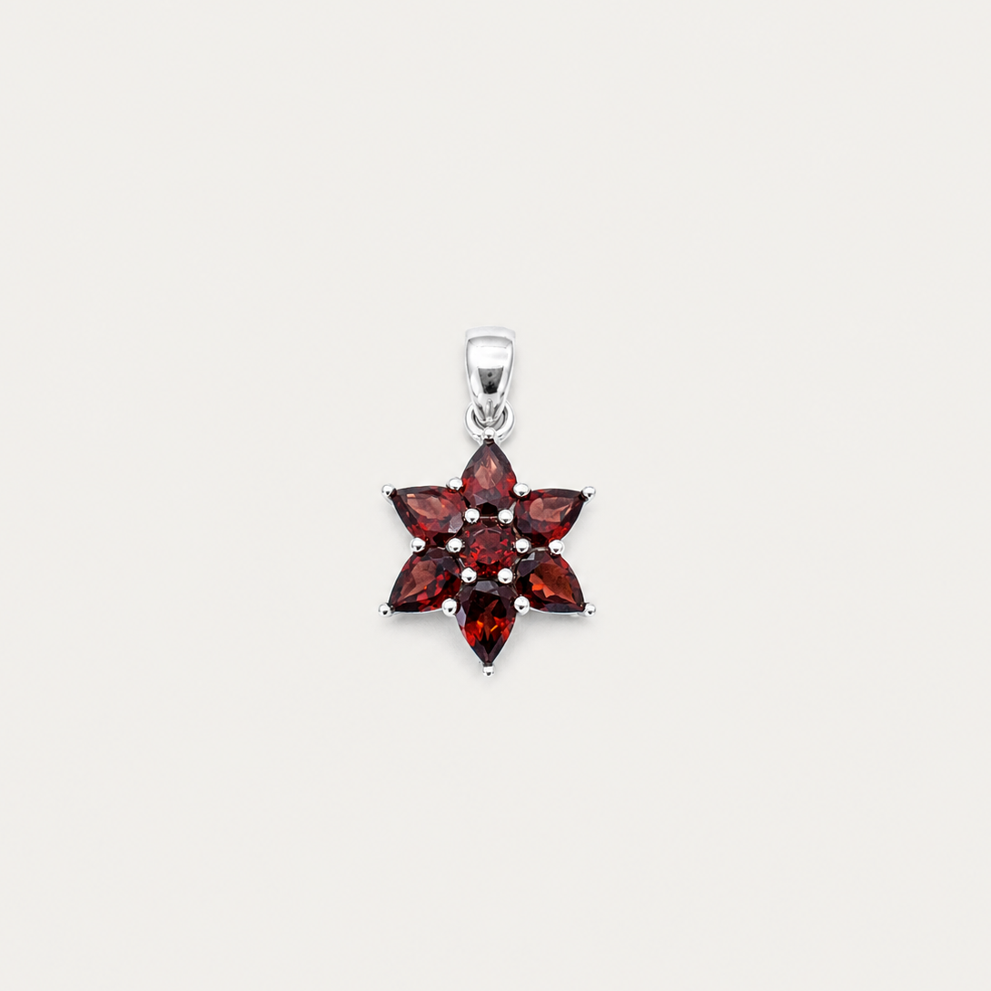 Star-shaped pendant with red gemstones on a white background